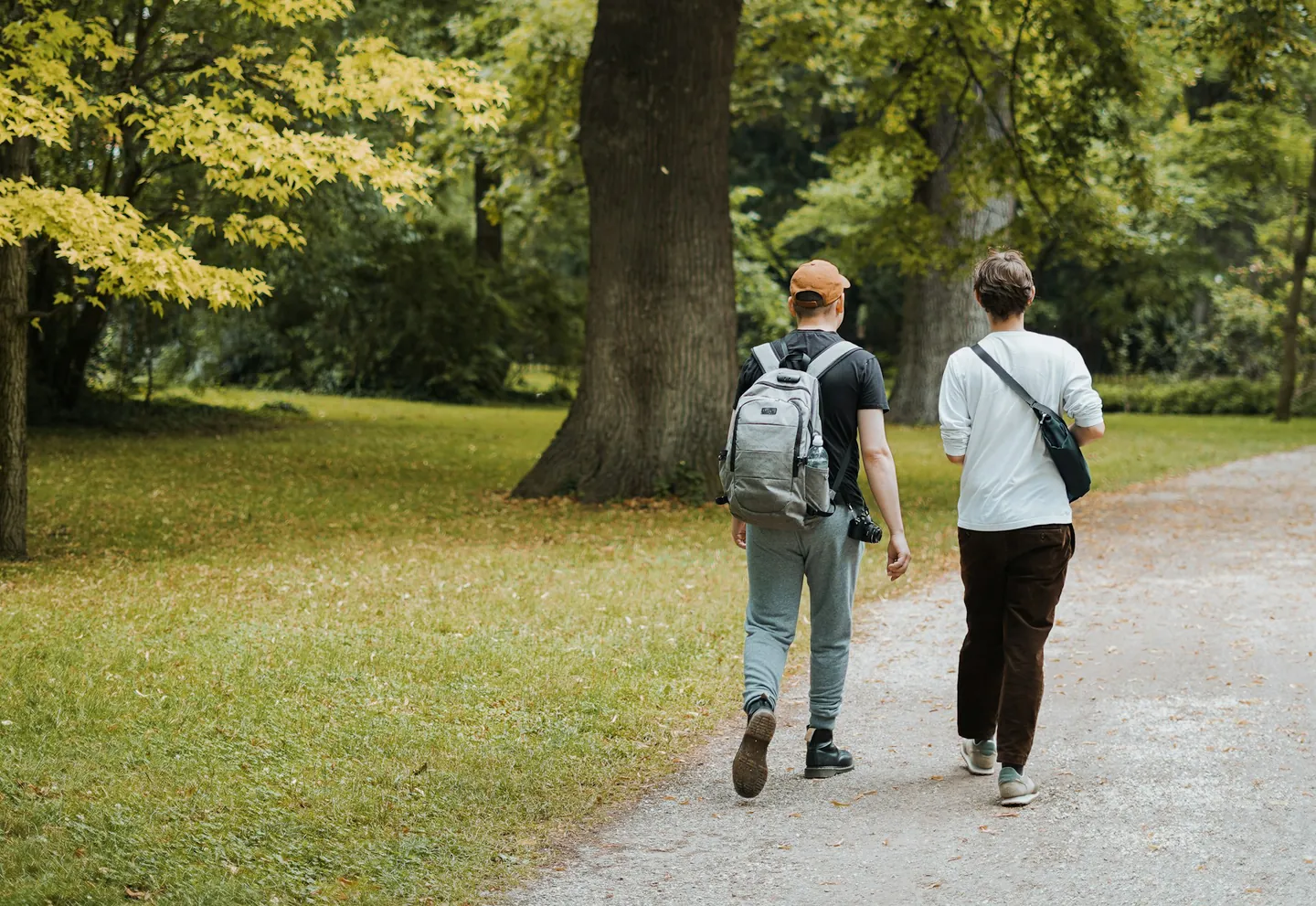 Twee mensen wandelen samen over een pad in een groen park